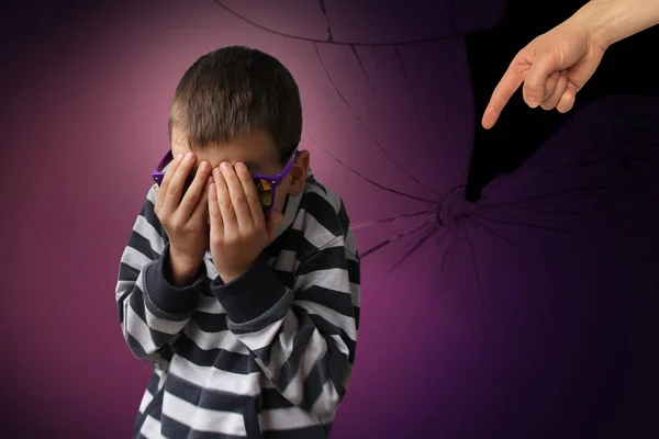 Junge in gestreiftem Pullover, der die Geste der erwachsenen Hand beschuldigt, weint und bedeckt sein Gesicht mit Angst, Hintergrund mit Rissen, Splittern, Begriff der Bestrafung, psychische und physische Gewalt — Stockfoto