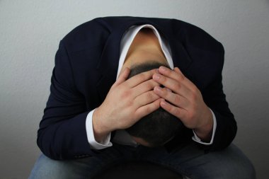 İş adamı, başı elinde oturuyor, sorunların sembolü, acı, hastalık, sağlık muayenesi, yakın plan, kopyalama alanı