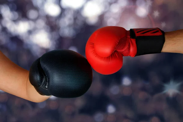 Close-up handen van twee boxers in rood en zwart bokshandschoenen gesloten voor sport begroeting op donkere achtergrond met ruimte voor kopieertekst — Stockfoto