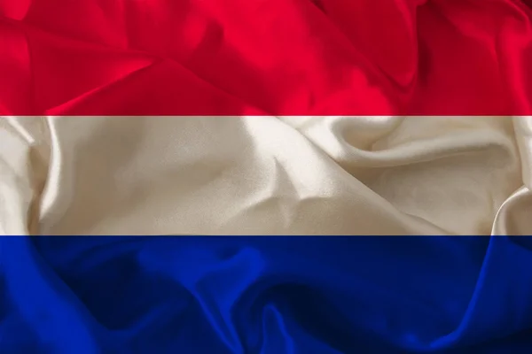 Mooie foto van de gekleurde nationale vlag van de moderne staat van Nederland op texturaal weefsel, concept van toerisme, emigratie, economie en politiek, close-up — Stockfoto