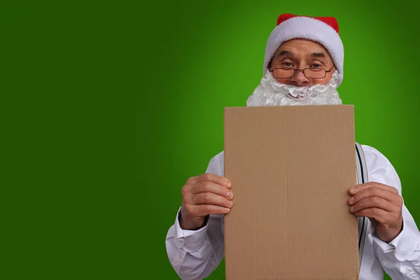 Santa Claus in glasses, in a white shirt with suspenders, holds a sheet of cardboard in his hands, blank form, mock up, Christmas concept, close-up — Stock Photo, Image