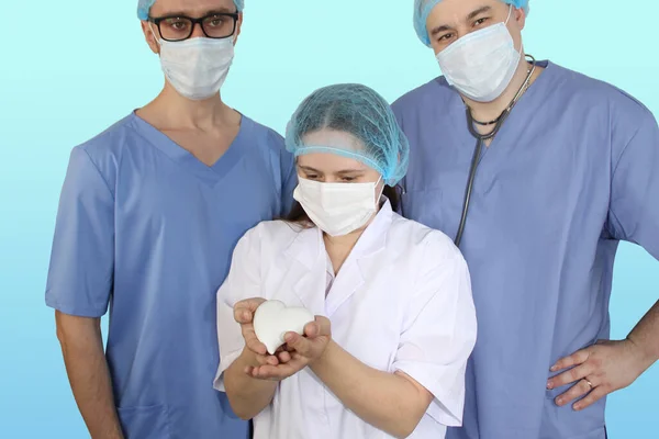 Три Масковані Лікарі Разом Дівчина Тримає Руках Модель Серця Концепцію — стокове фото