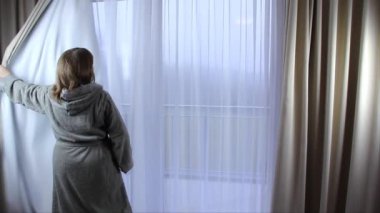 Otel odasında bornoz giyen orta yaşlı bir kadın, tatil konsepti, seyahat, yaşam tarzı