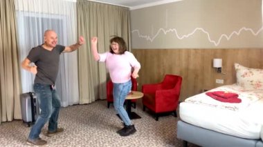 pozitif çift, bornozlu kadın ve erkek otel odasında dans ediyorlar, tatil, seyahat, yaşam tarzı