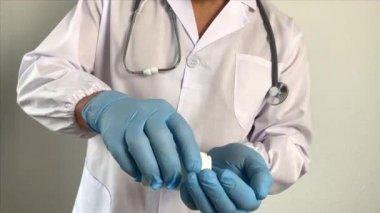 Eczacı, üniformalı doktor bir aşı üretiyor, elinde haplar, haplar, yeni ilaçlar, elinde diyet takviyesi, ilaç konsepti, koronavirüs tedavisi, COVID-19