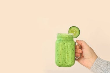 Kızlar, salatalıktan, kırmızı biberden, ıspanaktan, sağlıklı beslenme kavramından, vejetaryenlikten yapılmış sağlıklı sebzelerle dolu mason kavanozu tutuyor.