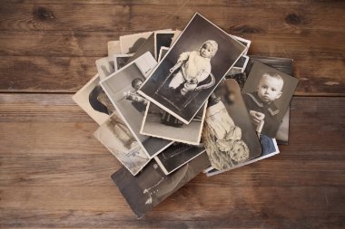 sepia renginde eski tek renkli fotoğraflar ahşap bir masaya saçılmıştır, soy ağacı konsepti, atalarımızın anıları, aile bağları, çocukluk anıları.