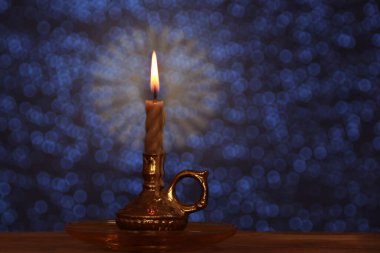 Mum, karanlık bir odada, bir şamdanda parlak bir alevle yanar. Sihir, dua, ruhanilik, yas tutma kavramı.  