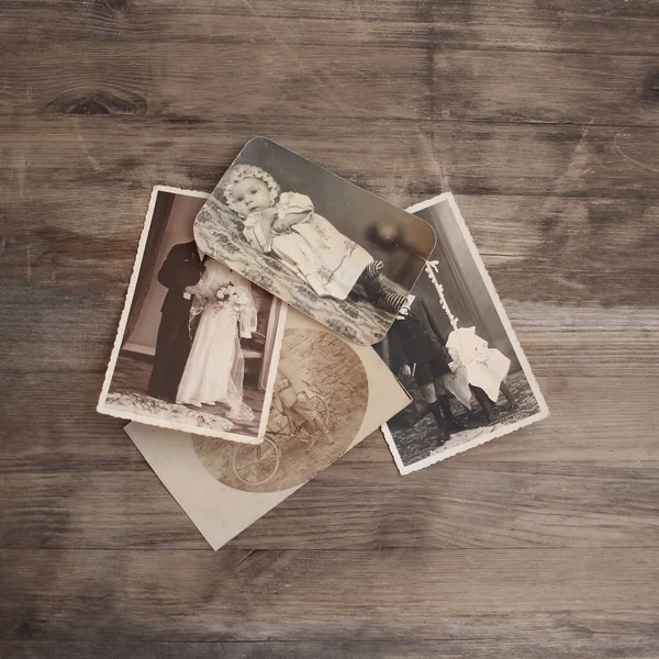 セピア色の古いヴィンテージのモノクロ写真は 木製のテーブルに散在しています 系譜の概念 祖先の記憶 家族の絆 子供の頃の思い出 — ストック写真