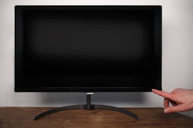 Frankfurt, Almanya - Haziran 2020: Adam bilgisayar monitörü Philips 'te düğmeye basıyor, 4k düz ekran LCD, siyah boş model, geniş ekran, iş sunumunuzu aygıt ekranında göster