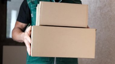 Kurye, üniformalı postacı adrese bir paket getirdi ve müşterilere verdi. Sipariş edilen malların teslimi, online alışveriş konsepti, erkek işi.