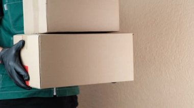 Kurye, üniformalı postacı adrese bir paket getirdi ve müşterilere verdi. Sipariş edilen malların teslimi, online alışveriş konsepti, erkek işi.