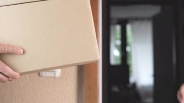 Üniformalı işçi adrese bir paket getirdi ve müşterilere, siparişlerin teslimatına, online alışveriş konseptine verdi.