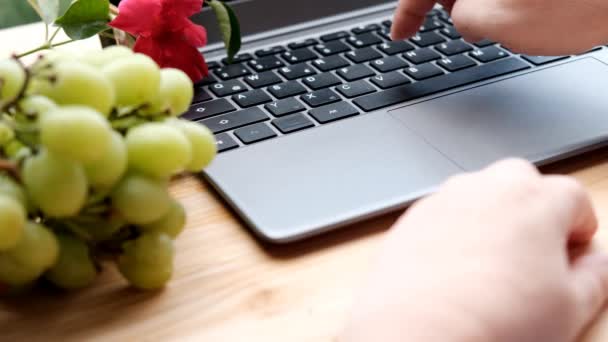 woman, girl surfing the internet in a laptop, closeup keyboard, fruit, flowers, work at home, workplace, downshifting, blogger, internet, content maker, remote work, selective focus
