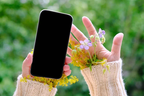 Kleine Blumensträuße Den Ärmeln Eines Pullovers Ein Modernes Handy Mit — Stockfoto