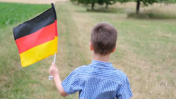 Kleine Jongen Loopt Langs Weg Tussen Velden Met Duitse Vlag — Stockvideo