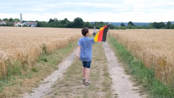 Bambino Sta Camminando Lungo Strada Tra Campi Con Bandiera Tedesca — Video Stock