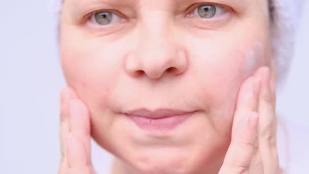 大人の女性はしわで顔のマッサージをしたり指を叩いたり美容の概念や老化肌ケアのための天然化粧品 — ストック動画