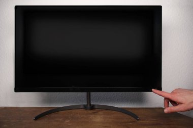 Adam 4k 'lık bir LCD monitördeki bir düğmeye, bir televizyon modellemesine, siyah boş bir HD monitör modeline, modern bir video paneline parmak basıyor. Geniş ekran aygıt ekranında iş sunumunuzu gösterin