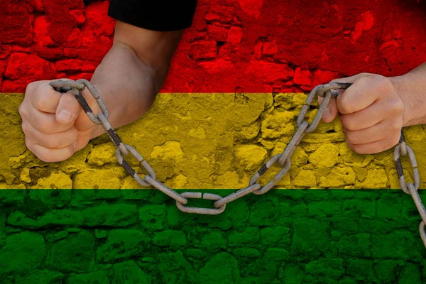 Bulgariamale hands break iron chain, symbol of bondage, protest against background of national flag of bolivia, concept of political repression, arrest, crime, violations of civil rights, freedom