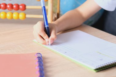 Çocuk tahtaya bir defter çizer ve yazar, okul yılının başlangıcı konsepti, ödevler, dersler, okula dönüş.