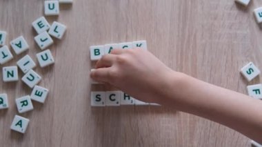 Çocuklar ahşap bir masanın üzerindeki harflerden okula geri dönmekten, okul yılının başlangıcından, ödevlerden, derslerden,