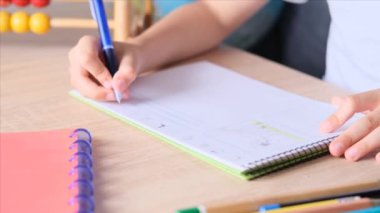 Çocuk tahtaya bir defter çizer ve yazar, okul yılının başlangıcı konsepti, ödevler, dersler, okula dönüş.