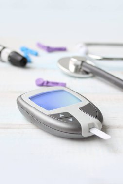 Dijital glukometre ve neşter kalem, stetoskop, vitrodaki kan, beyaz arka plan, sağlık konsepti, tıbbi teknoloji, hasta izleme