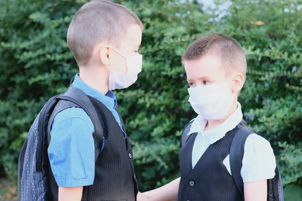 Dois Meninos Escolares Com Máscaras Médicas Brancas Seus Rostos Conversando — Fotografia de Stock
