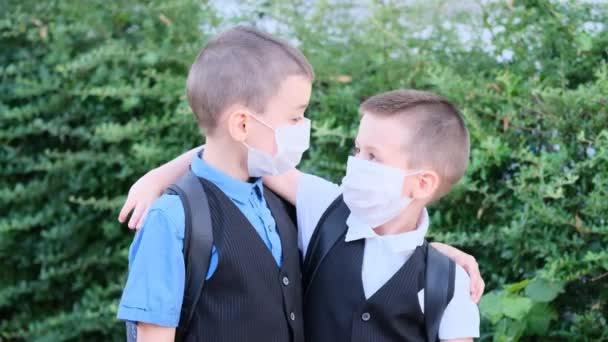 Dos Niños Escolares Con Máscaras Médicas Blancas Cara Hablando Entre — Vídeos de Stock