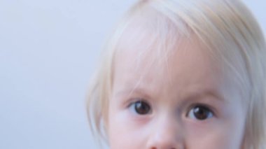 Bebeğim, yüzünün bir parçası, yakın çekimde komik kahverengi gözler, anne kızın saçlarını tarıyor, bebek hijyeni konsepti, bebek saçı, saç kesimi