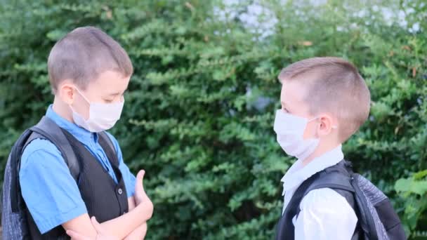 Dois Meninos Escolares Com Máscaras Médicas Brancas Seus Rostos Conversando — Vídeo de Stock