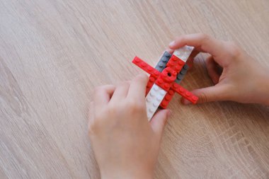 Çocuk, çocuk inşaatçının detaylarıyla oynar, yeni oyuncaklar yaratır, zihinsel yeteneklerin gelişimi konsepti, mantık, uzaysal temsiller, aile eğlencesi
