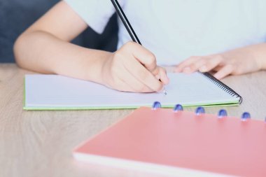 Çocuk tahtaya bir defter çizer ve yazar, okul yılının başlangıcı konsepti, ödevler, dersler, okula dönüş.