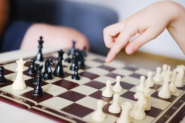 boy, kid plays with his father, an adult in chess, the concept of the development of mental abilities, logic, the ability to play, family entertainment, joint games, business, victory