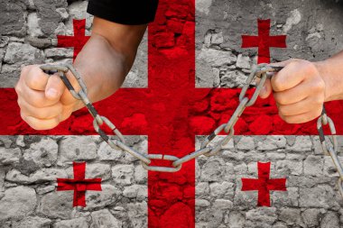 Erkek eller demir zinciri kırıyor, köleliğin sembolü, Gürcistan bayrağının arka planını protesto ediyor, siyasi baskı, tutuklama, suç, sivil haklar, özgürlük kavramını protesto ediyor.