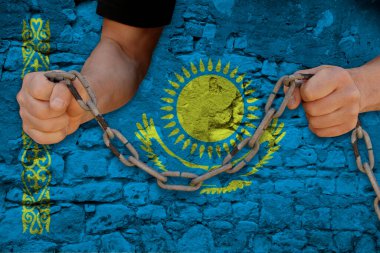 Erkek elleri, köleliğin sembolü olan demir zinciri kırar Kazakistan 'ın ulusal bayrağının arka planını protesto eder. Siyasi baskı, tutuklama, suç, sivil haklar, özgürlük kavramını protesto eder.