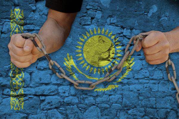 male hands break the iron chain, a symbol of bondage,protest against the background of the national flag of Kazakhstan, the concept of political repression, arrest, crime, civil rights, freedom