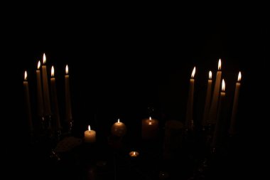 Karanlık bir odada, yuvarlak bir masada mumlar yanıyor, hayvan kafatasları yalan söylüyor, bir pentagram çiziliyor, kırmızı bir kalp modeli, mumlar, bir sihir konsepti, büyücülük...