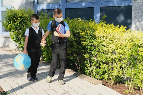 Δύο Αγόρια Μαθητές Μαύρες Σχολικές Στολές Σακίδια Ιατρική Μάσκα Πηγαίνουν — Φωτογραφία Αρχείου