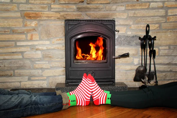 크리스마스 컨셉트인 불타는 벽난로 근처에서 남자와 다리가 있습니다 — 스톡 사진