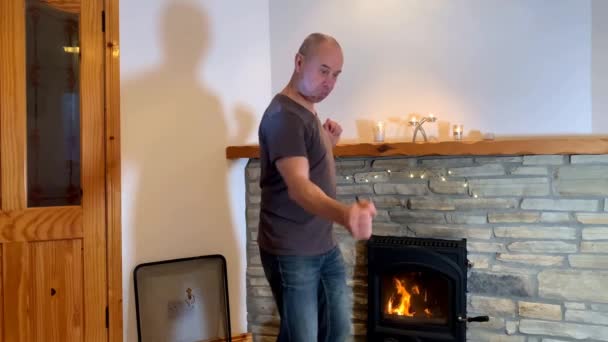Homem Alegre Meia Idade Que Dança Expressivamente Pela Lareira Ardente — Vídeo de Stock