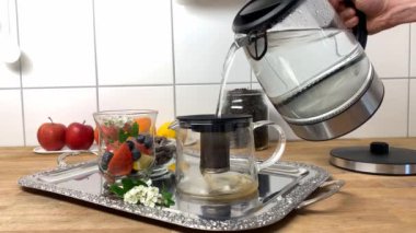 Adam çaydanlığa su döker, elma, böğürtlen, dikenli çiçek, arka planda meyve, sağlıklı beslenme konsepti, vitamin kahvaltısı...