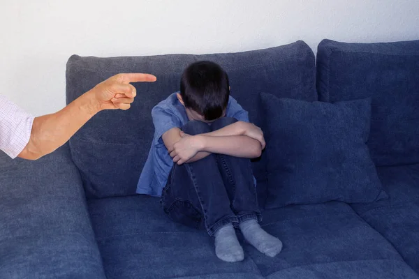 Smutne Dziecko Chłopiec Siedzący Szarej Sofie Pokoju Ściskający Kolana Dłońmi — Zdjęcie stockowe