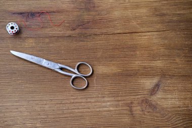 Eski demir makas eski bir ahşap masada yatar, iki parçanın ahengi, yaşam ve ölümün sembolü, kuaförlük, kesim ve dikiş.