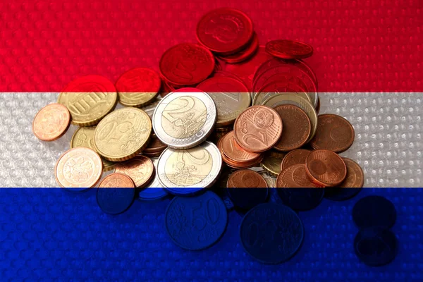 euro metal coins euro on the background of the national flag of the country of Netherlands, the concept of financial development, devaluation, inflation, taxes