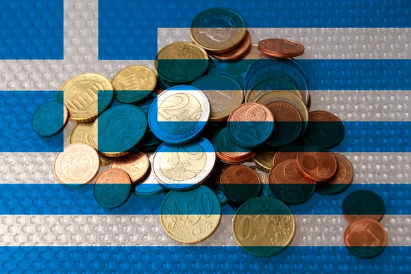 연합의 동전은 그리스의 국기를 배경으로 있으며 인플레이션 세금의 개념이다 — 스톡 사진