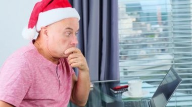 Noel Baba şapkalı genç adam pencerenin önünde duruyor, arkasında büyük Avrupa şehri görünüyor, seyahat konsepti, turizm, yeni yıl kutlaması, müdire, bayramı bekliyor, noel satışları,