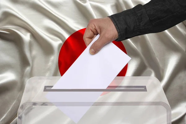 Mężczyzna Wyborca Upuszcza Karty Głosowania Przejrzystej Urnie Tle Flagi Narodowej — Zdjęcie stockowe