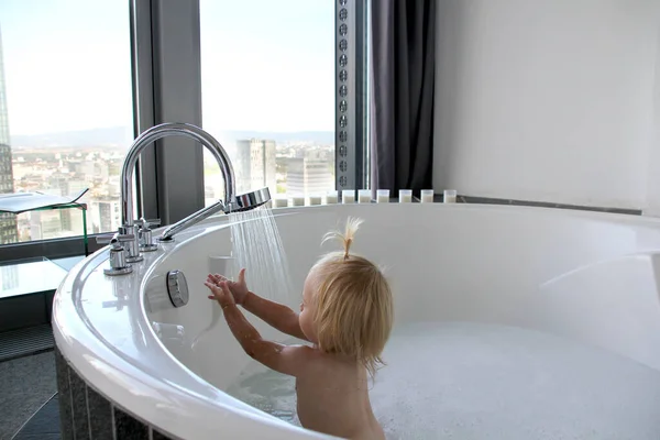 아기는 커다란 욕조에서 목욕하고 방에서자 쿠지를 — 스톡 사진